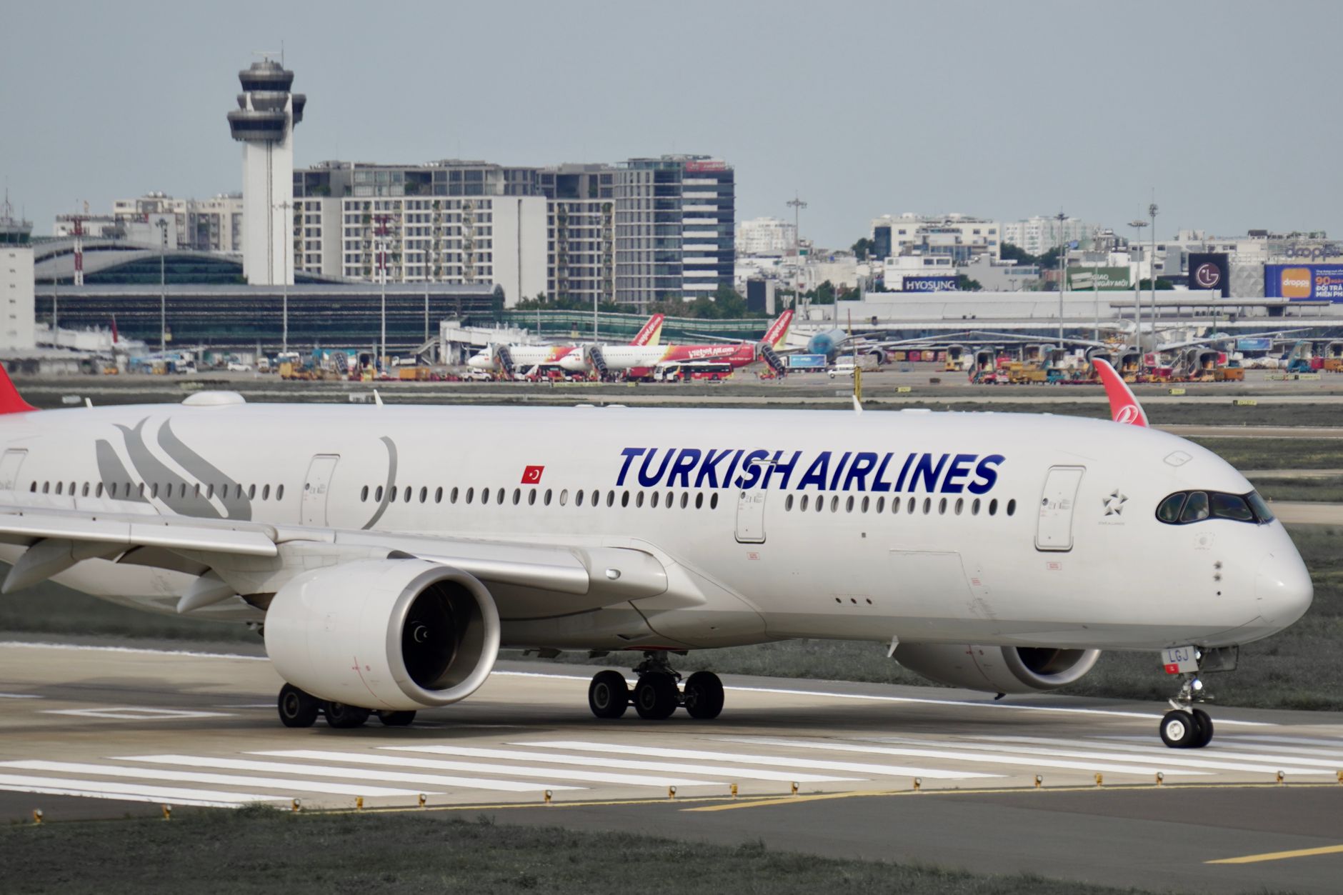 Samolot Turkish Airlines Airbus A350 kołuje po płycie ruchliwego lotniska