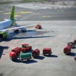 Samolot cargo na płycie lotniska z wózkami bagażowymi w słońcu