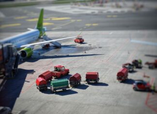 Transport lotniczy cargo: szanse dla polskich eksporterów i logistyki Samolot cargo na płycie lotniska z wózkami bagażowymi w słońcu