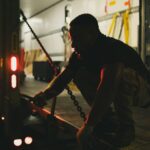 Mężczyzna zabezpiecza łańcuchy na ciężarówce nocą w Houston