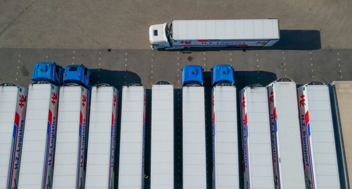 Widok z drona na rząd ciężarówek logistycznych na parkingu Widok z drona na rząd ciężarówek logistycznych na parkingu