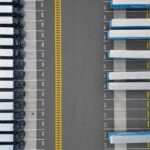 Ciężarówki ustawione w rzędach na parkingu logistycznym widziane z góry