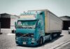 Niebieska ciężarówka Volvo zaparkowana przed magazynem przemysłowym
