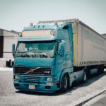 Niebieska ciężarówka Volvo zaparkowana przed magazynem przemysłowym