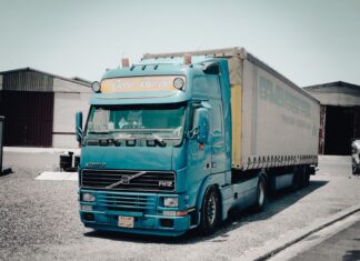Niebieska ciężarówka Volvo zaparkowana przed magazynem przemysłowym